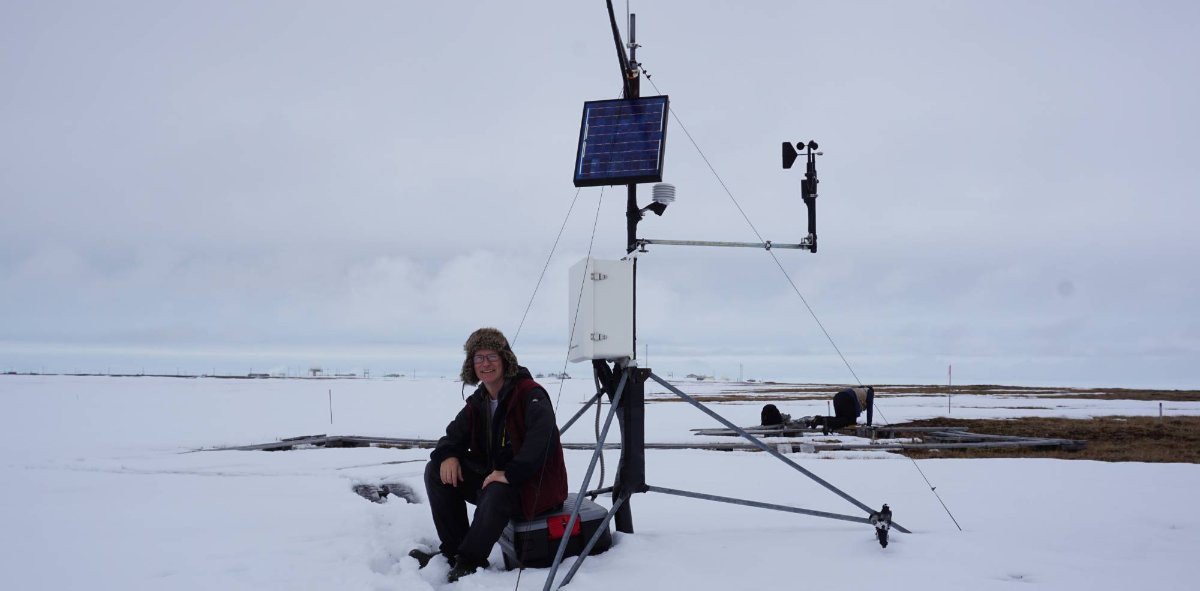 Bob Holister sitting next to scientific equipment in the Arctic