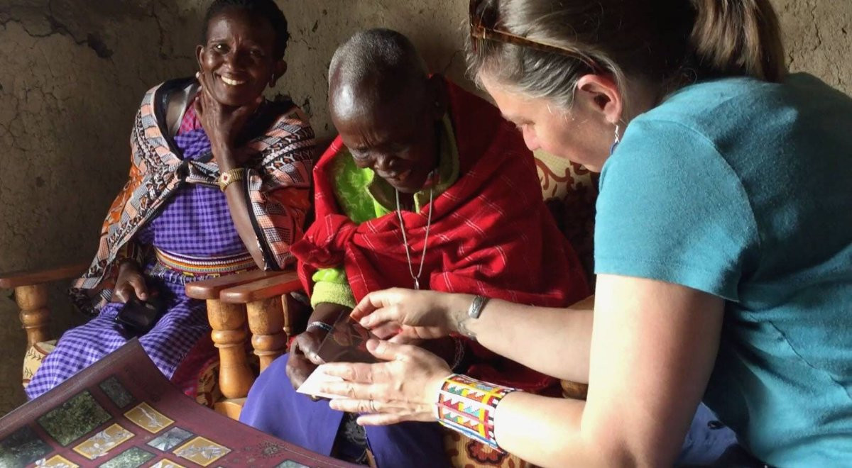 Kristen Hedges of Anthropology shows Maasai women the book created from their traditional plant medicine knowledge