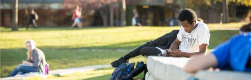 Student reading outdoors near Kirkhof Center