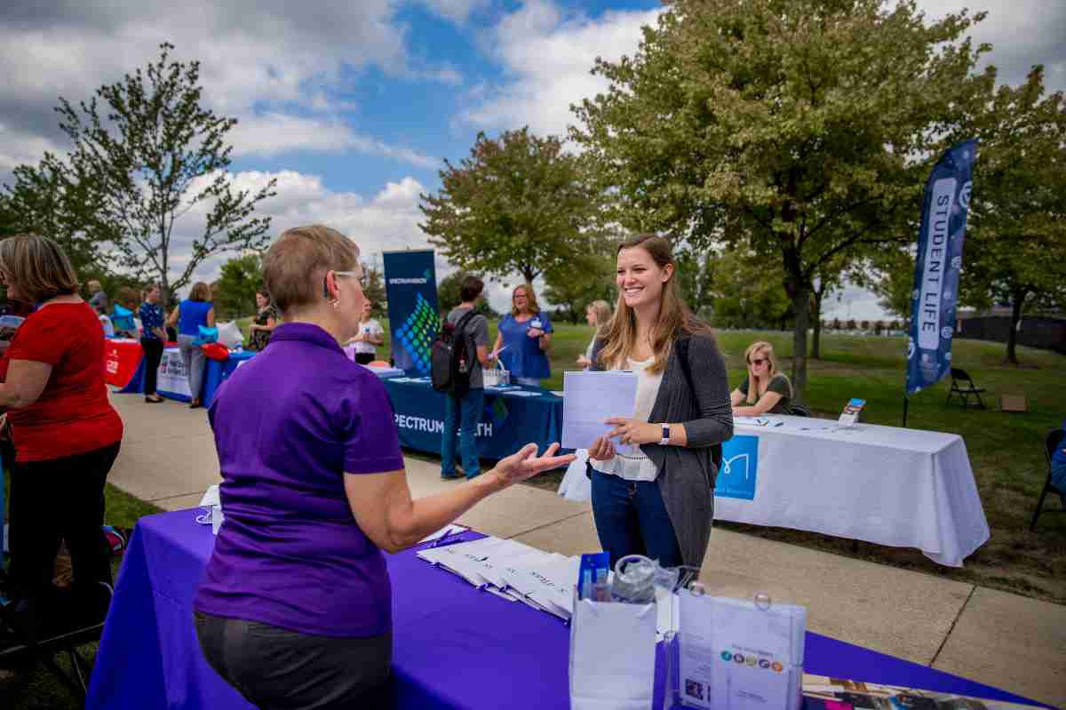 A representative from a company talking to a student at the career fair