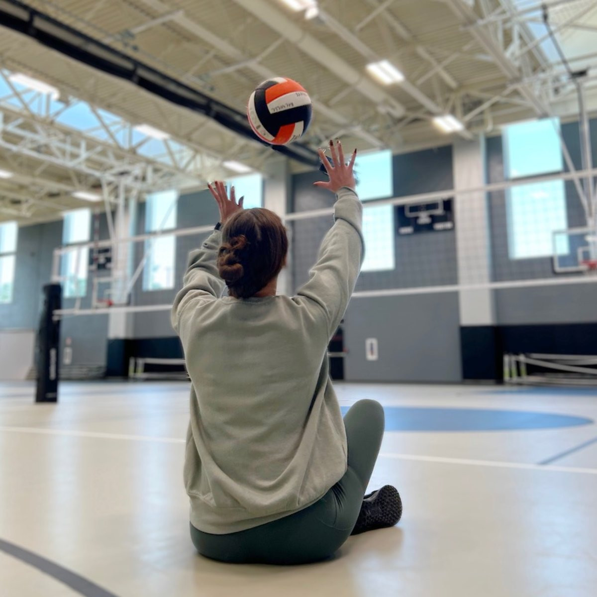 A girl participating in RecWell's seated volleyball
