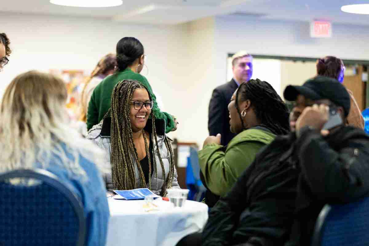 Two students talking and smiling at I Am GV event