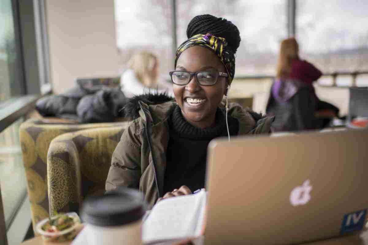 A student smiling while studying at the library