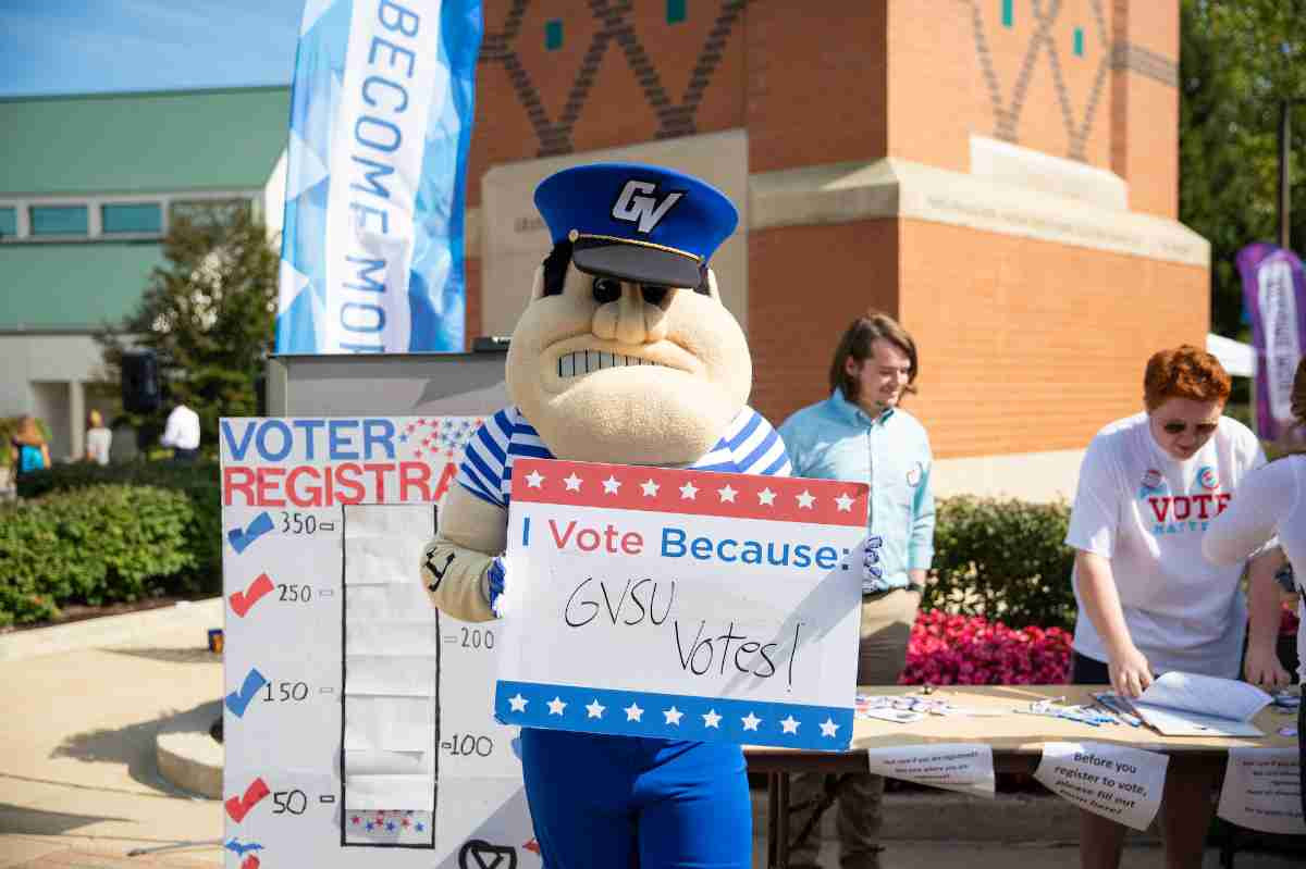 Louie the Laker holding a "I vote because GVSu Votes" sign