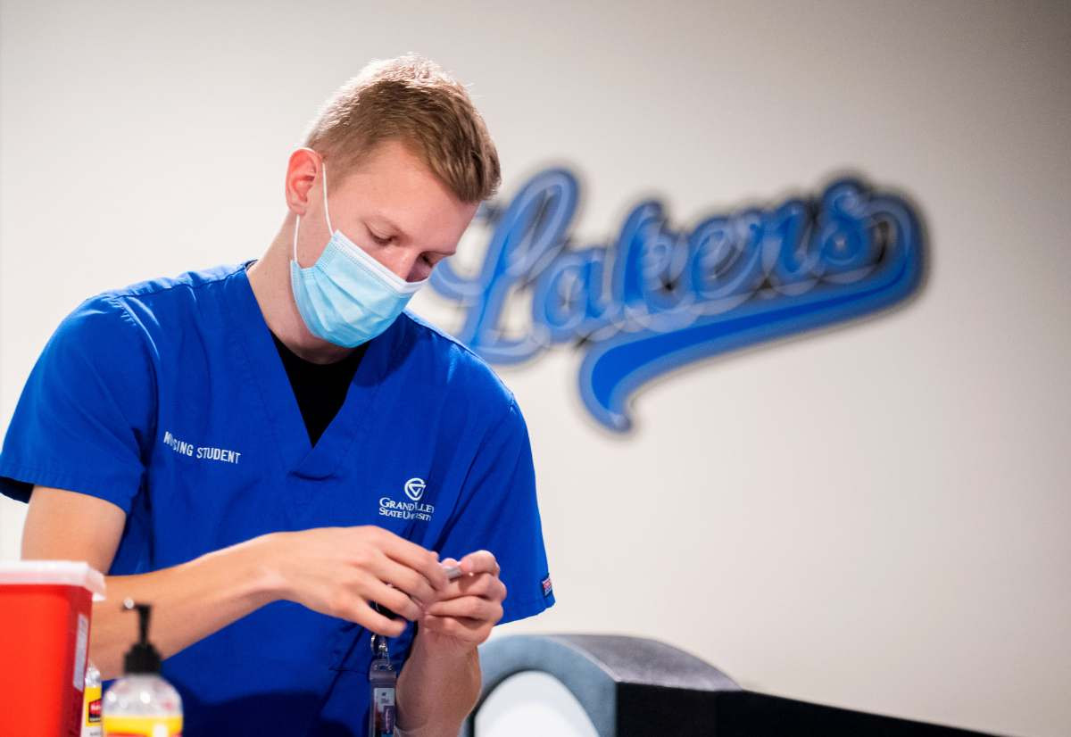 A nursing student getting a flu shot ready