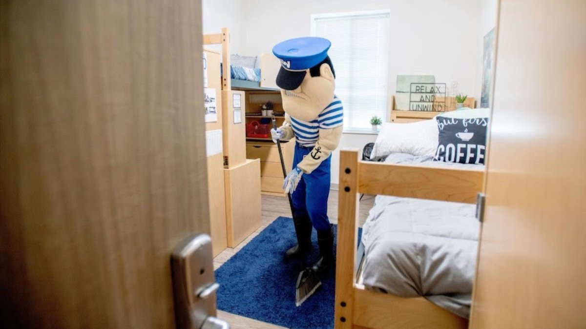 louie the laker cleaning a dorm room