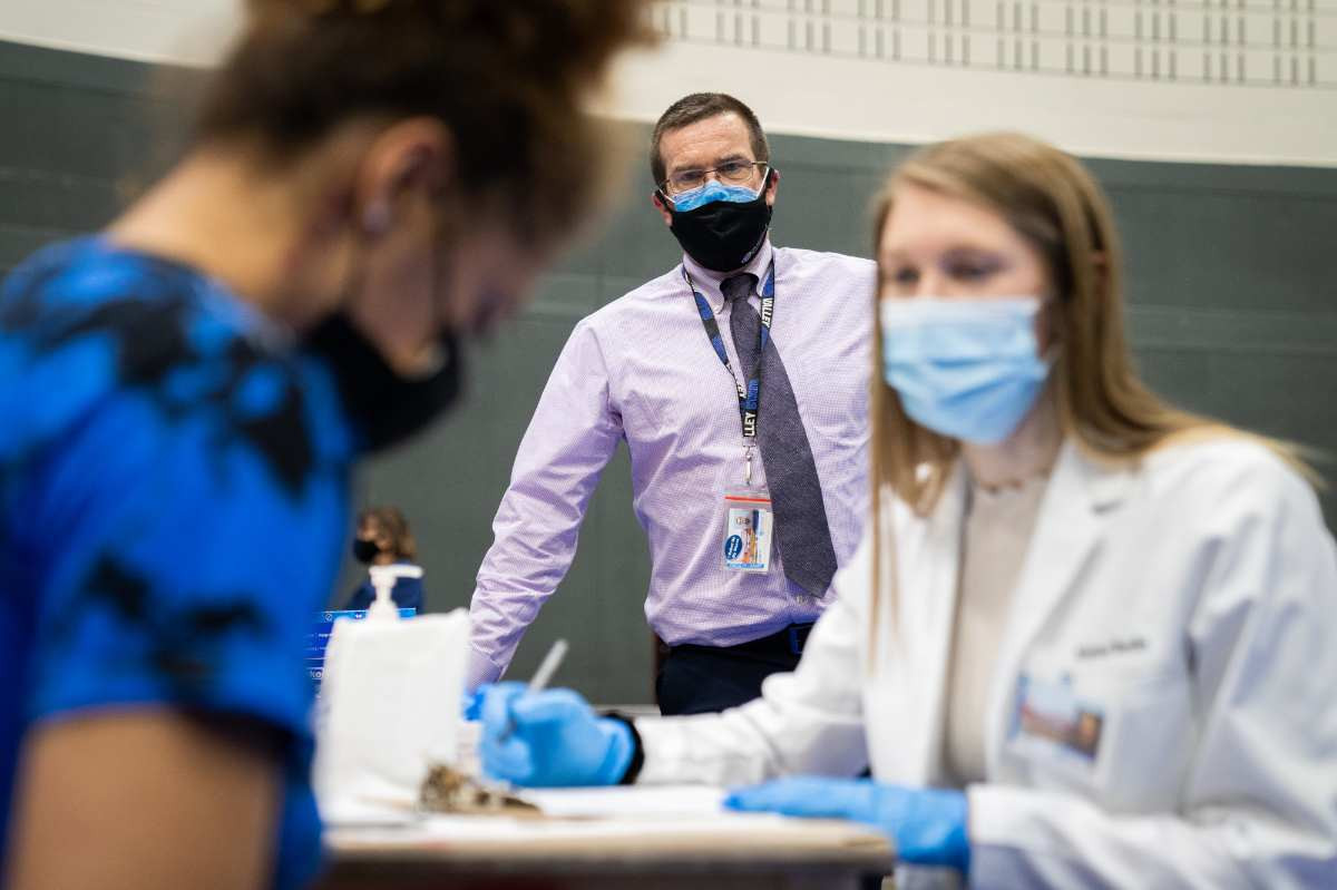 A nursing student talking to a patient at the covid vaccine clinic