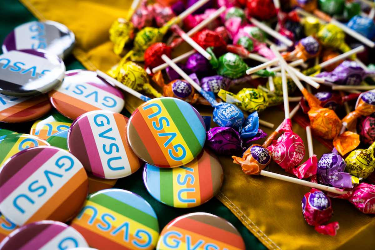 colorful pins that say gvsu and candy on a table