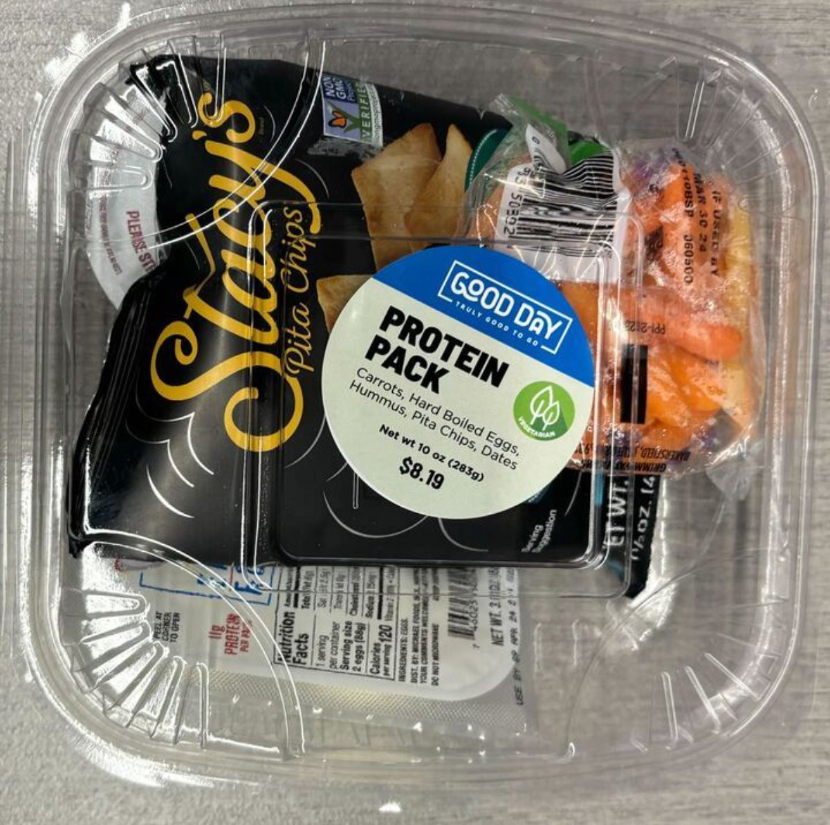 The protein pack snack that includes a bag of chips, carrots, a hard boiled egg, hummus and dates that are listed on the sticker Protein Pack by Good Day with $8.19