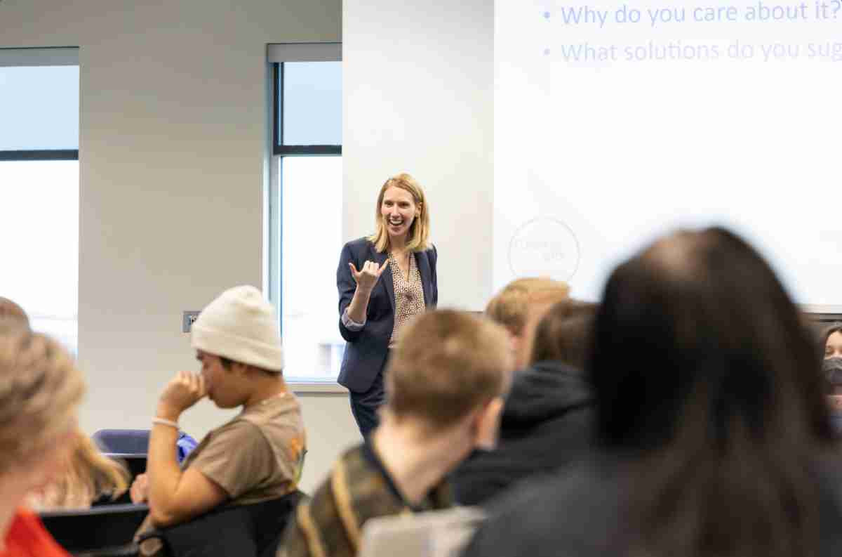 The Elect Her speak in the front of the room with an enthusiastic face