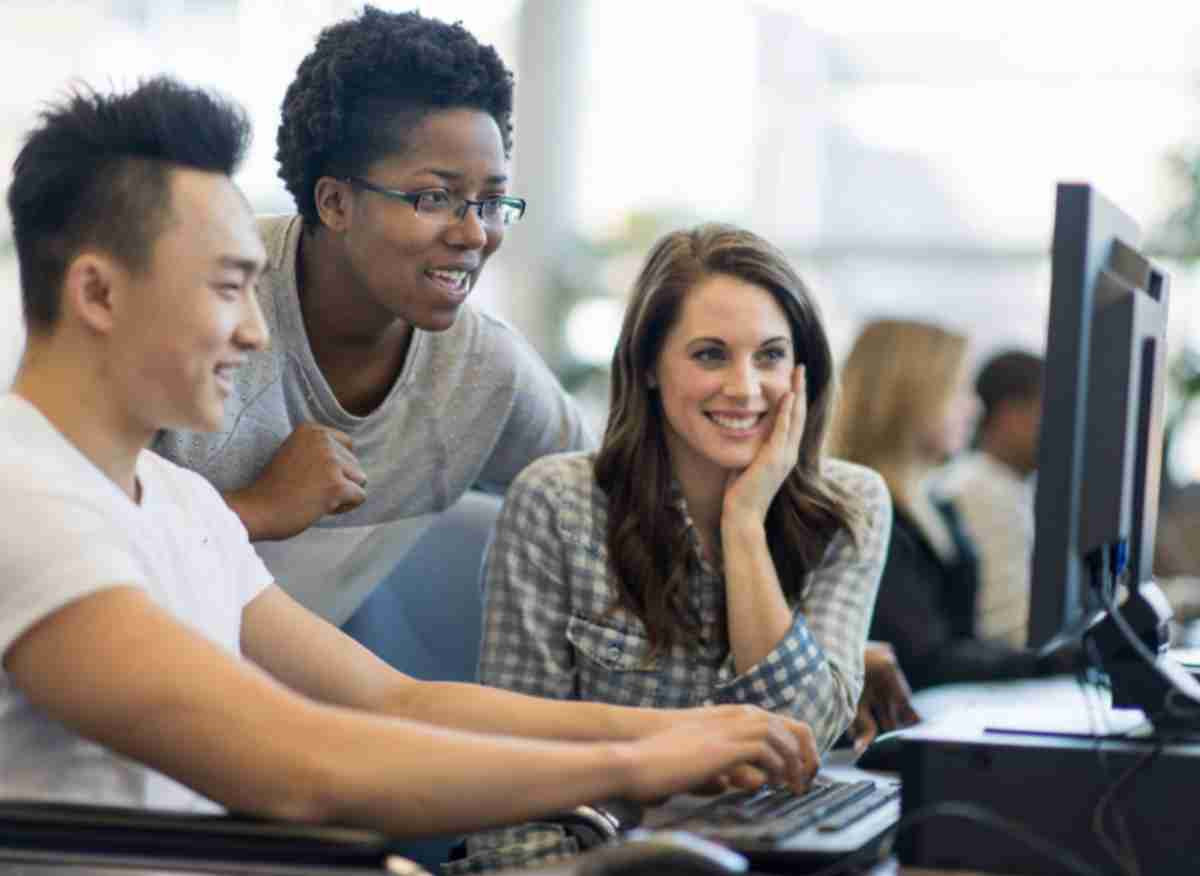 two students and an advisor sitting at a computer