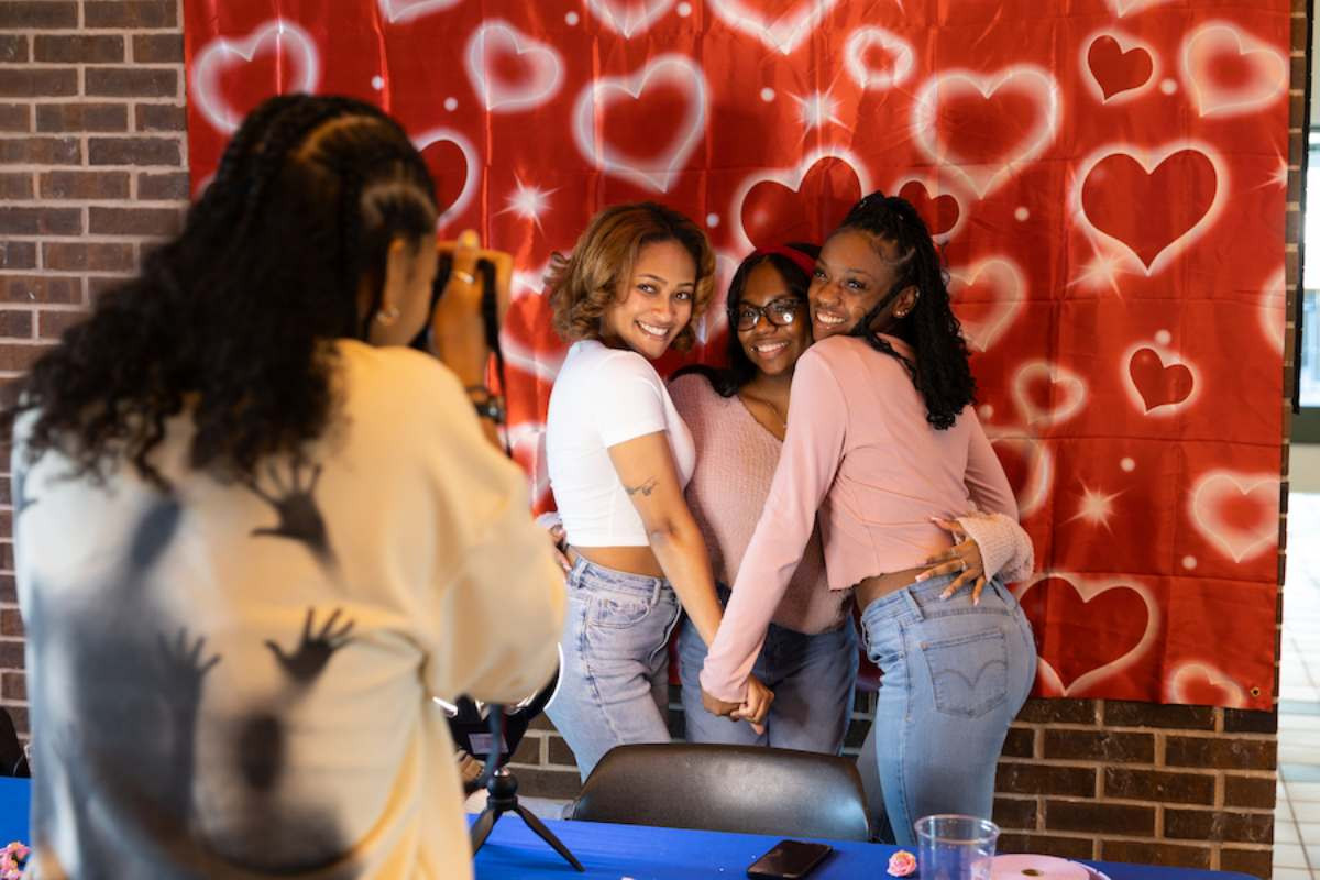 Three students smiling and posing for a picture during the Black Student Union's Love Carnival event