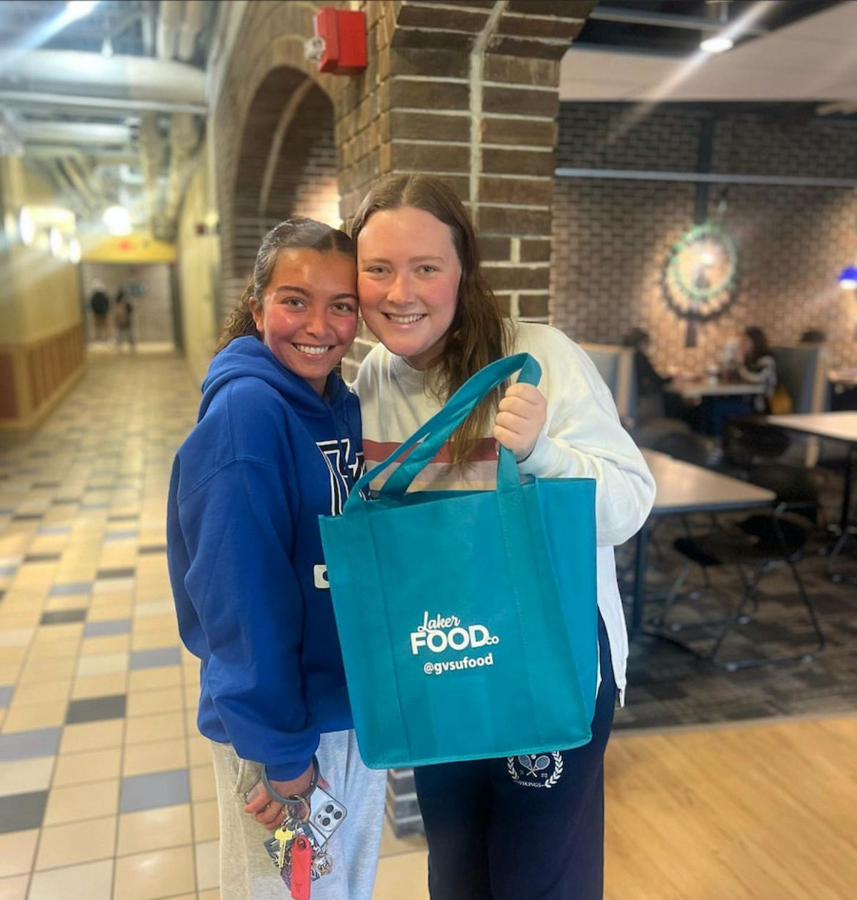 Two students going to Laker Food Co. and picking up a free goodie bag in honor of World Kindness Day