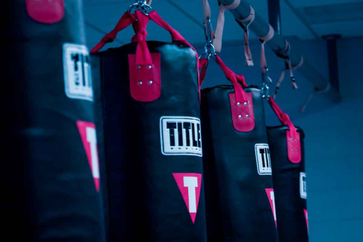 four kickboxing bags that have text that read Title and a red triangle with a white T
