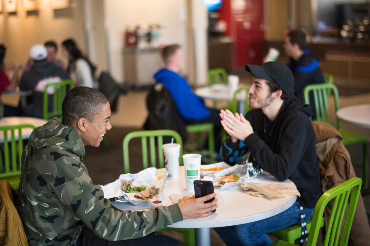 Two students sitting in Kleiner taking and eating