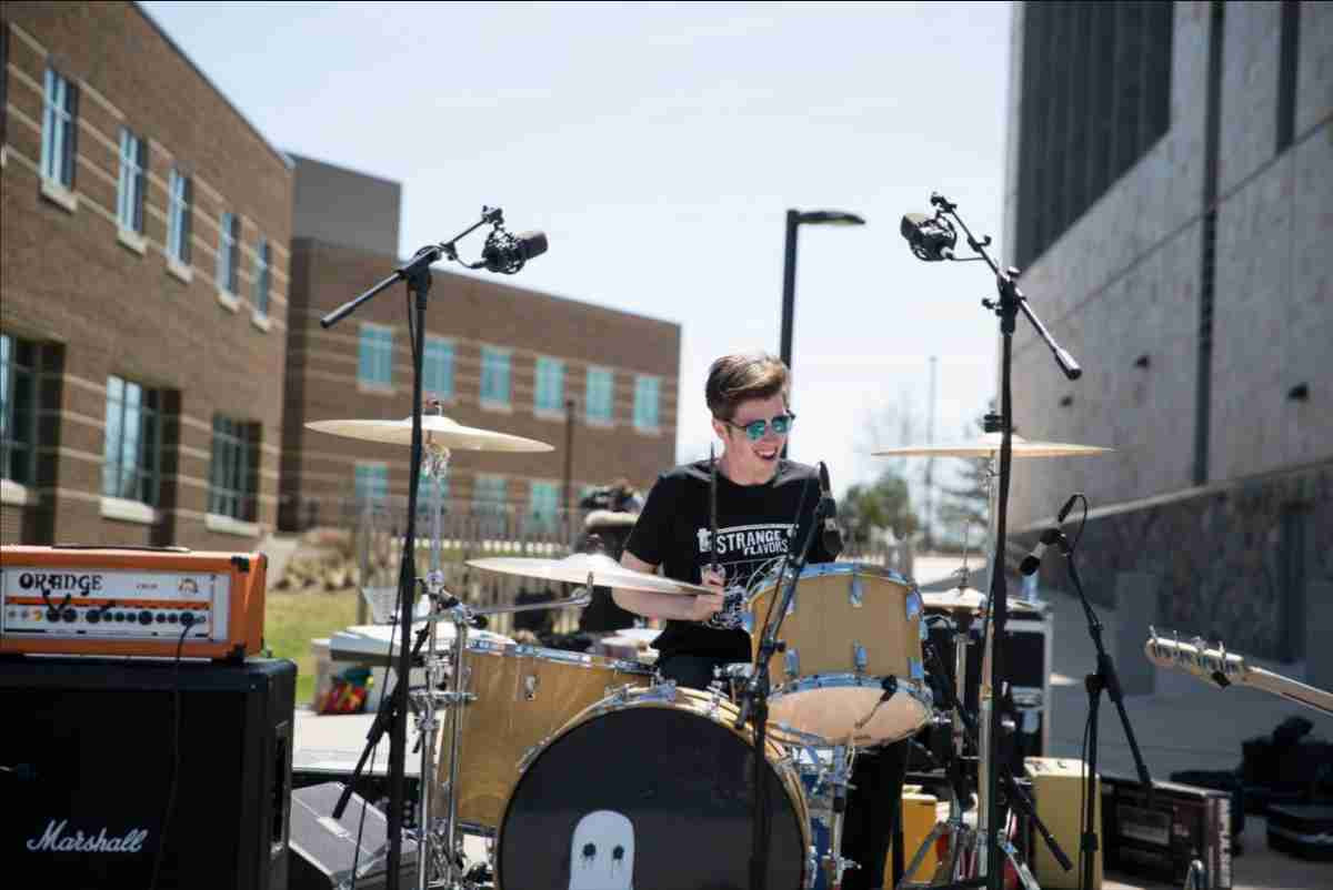 A drummer in a band playing the drums outside at LakePalooza