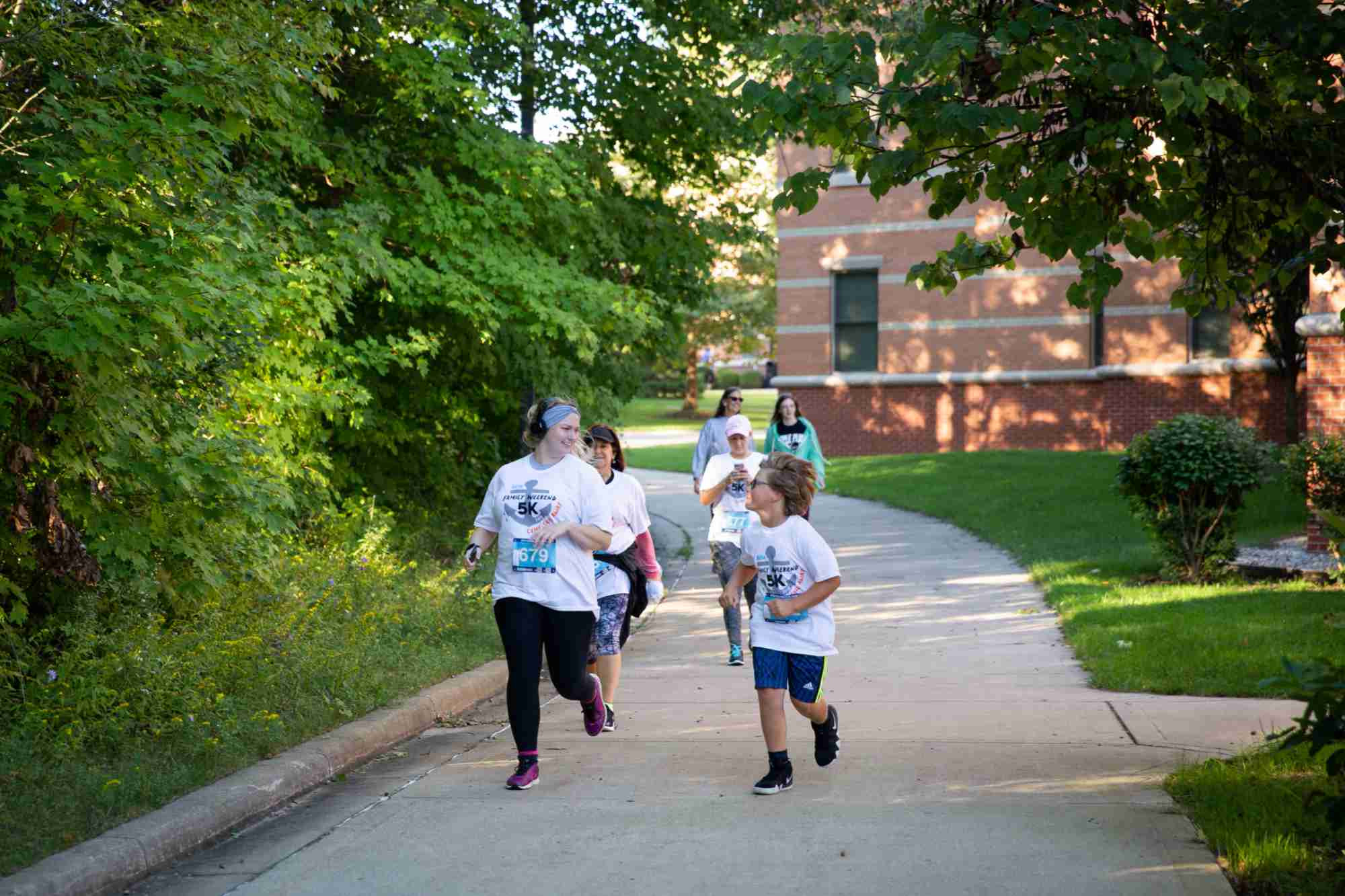 A family running on the sidewalk at Family Weekend