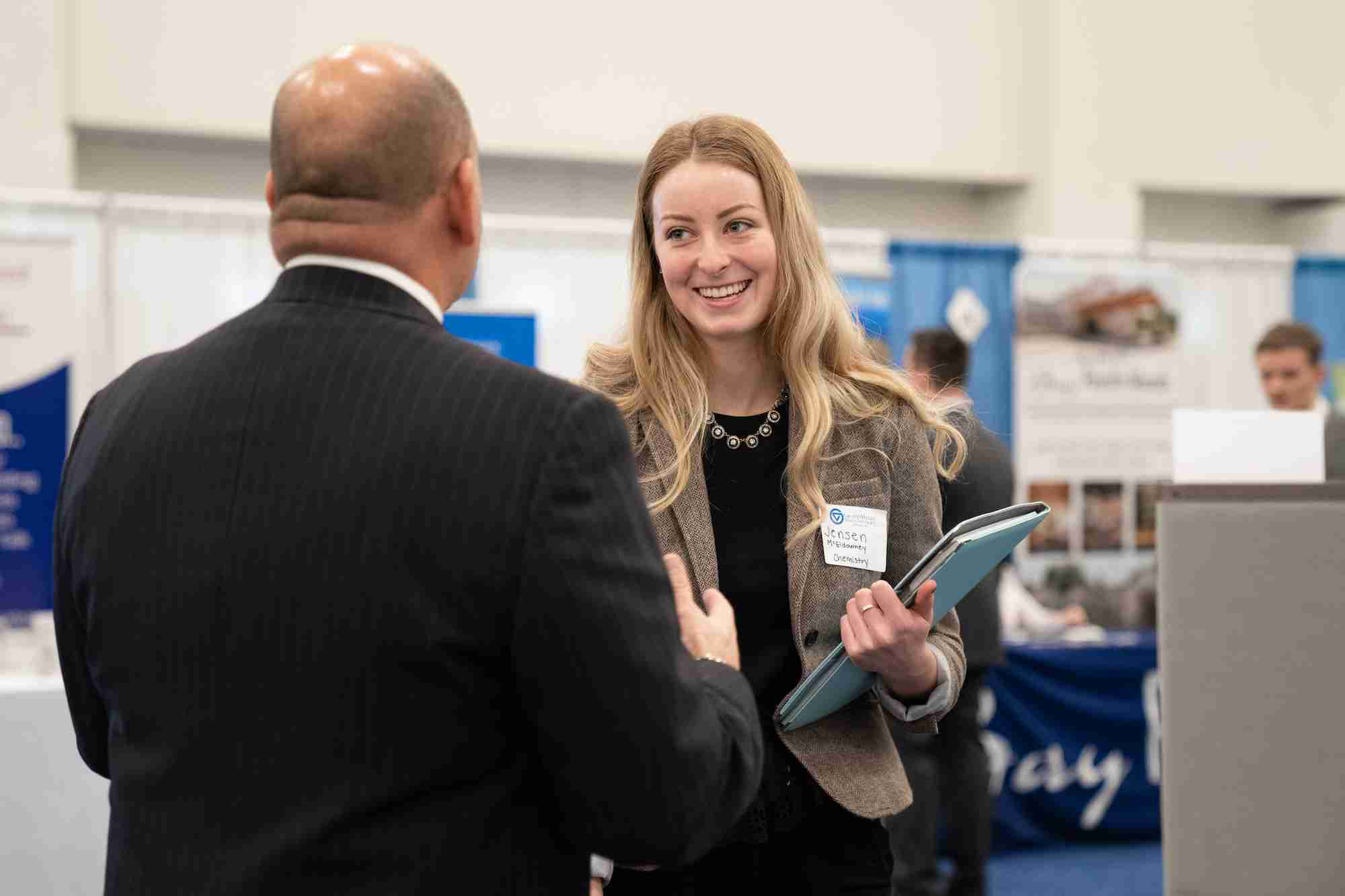 A student smiling and shaking someones hand