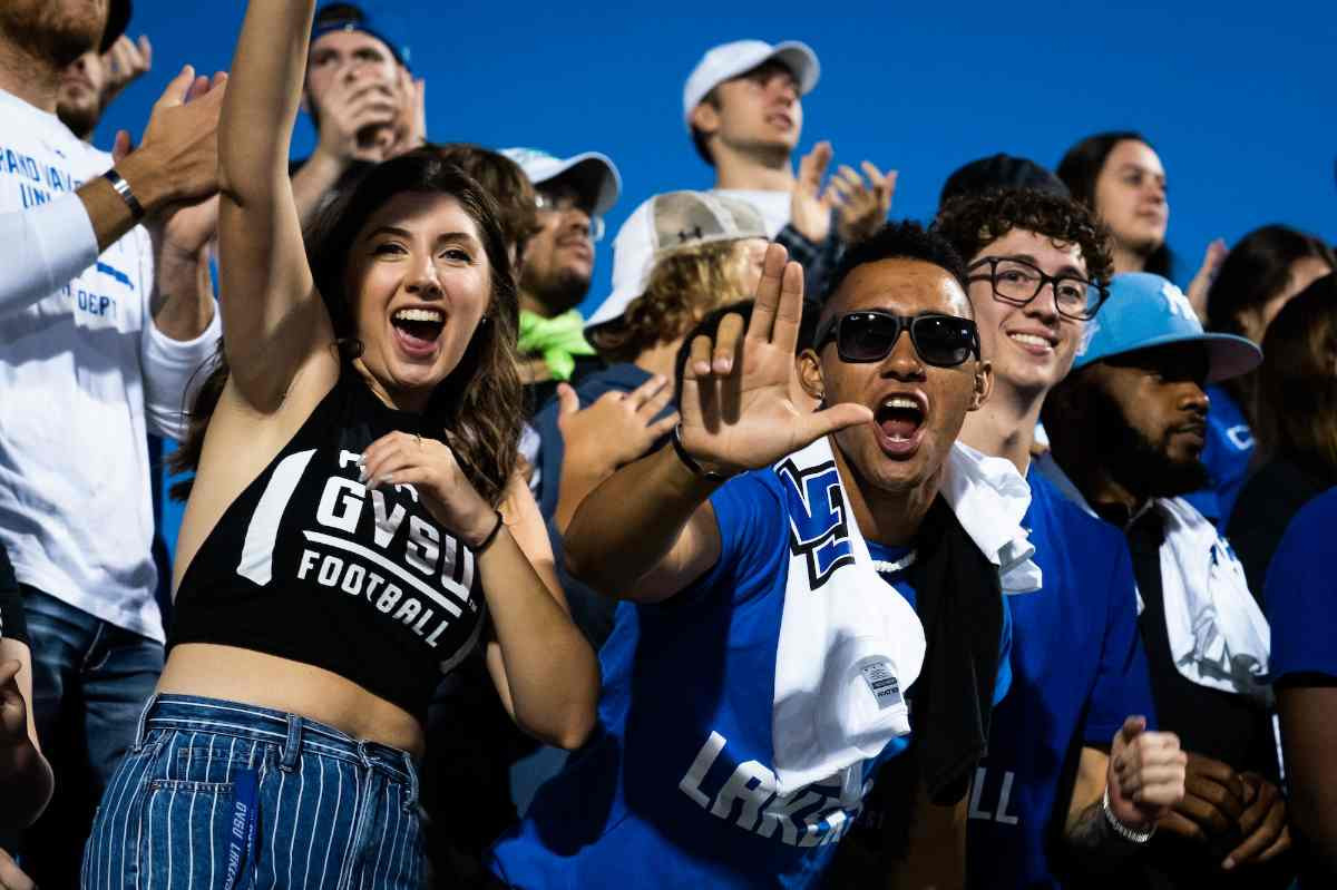 a group of students cheering at a GVSU football game