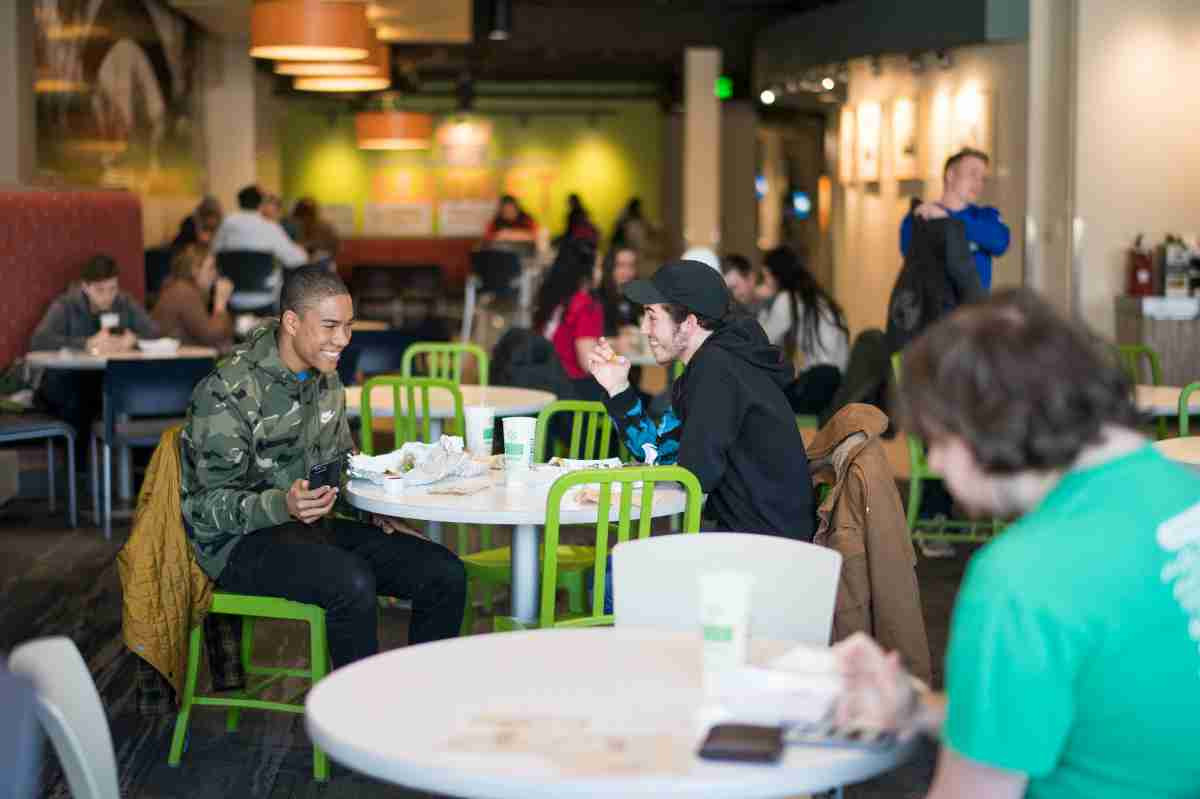 Students sitting in Kleiner eating and laughing