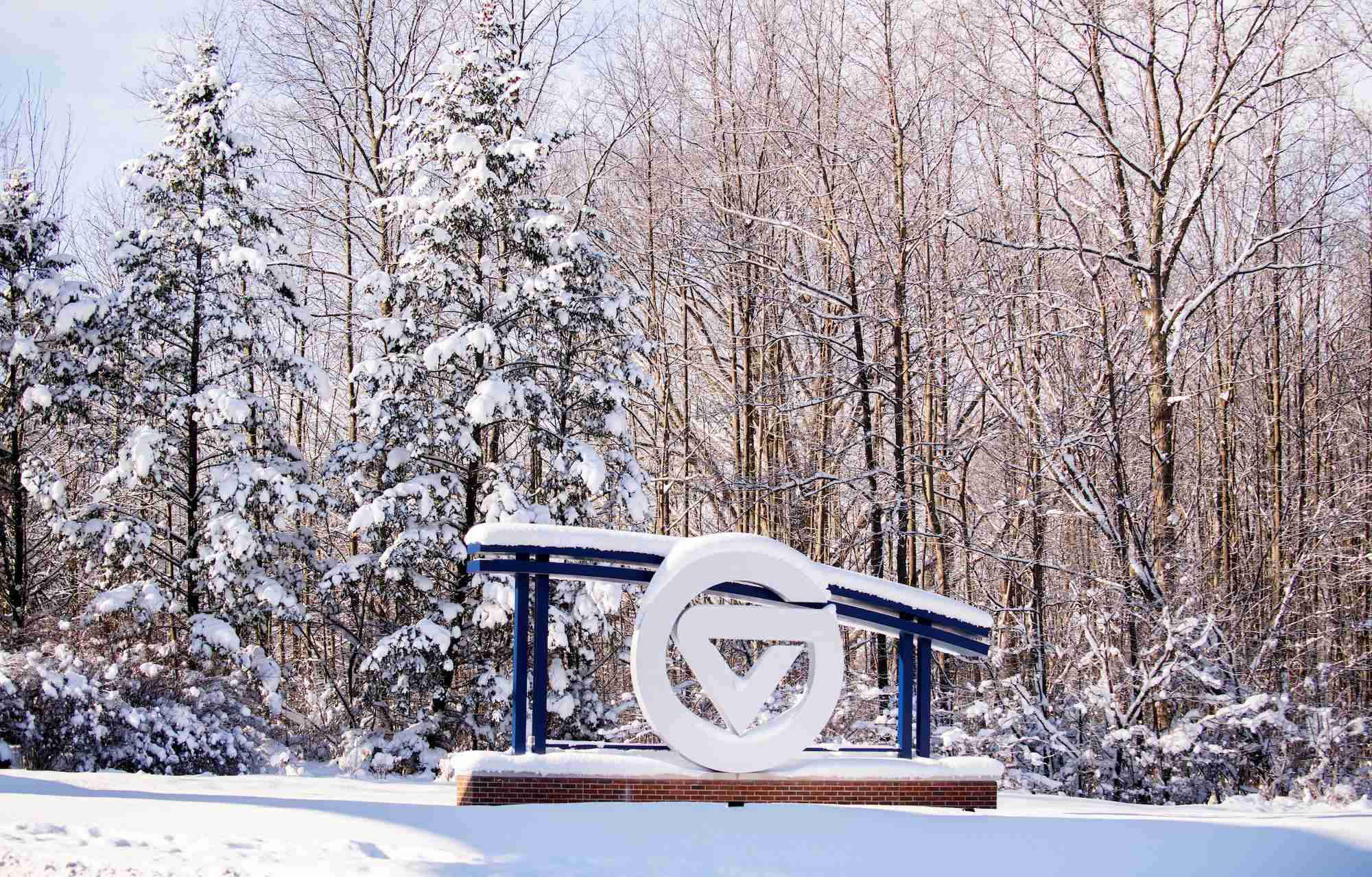 Snow covering the Grand Valley sign by the main campus entrance