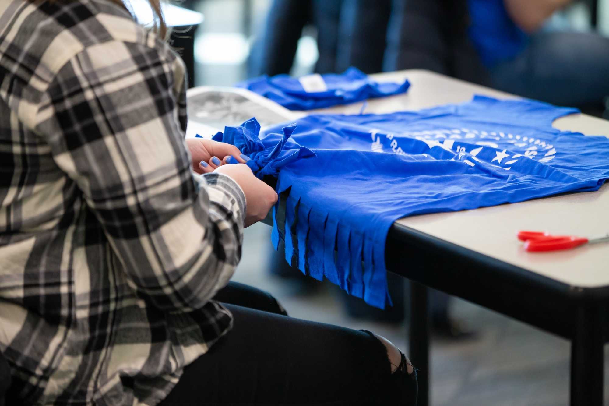 Student tying dog ties out of t-shirts