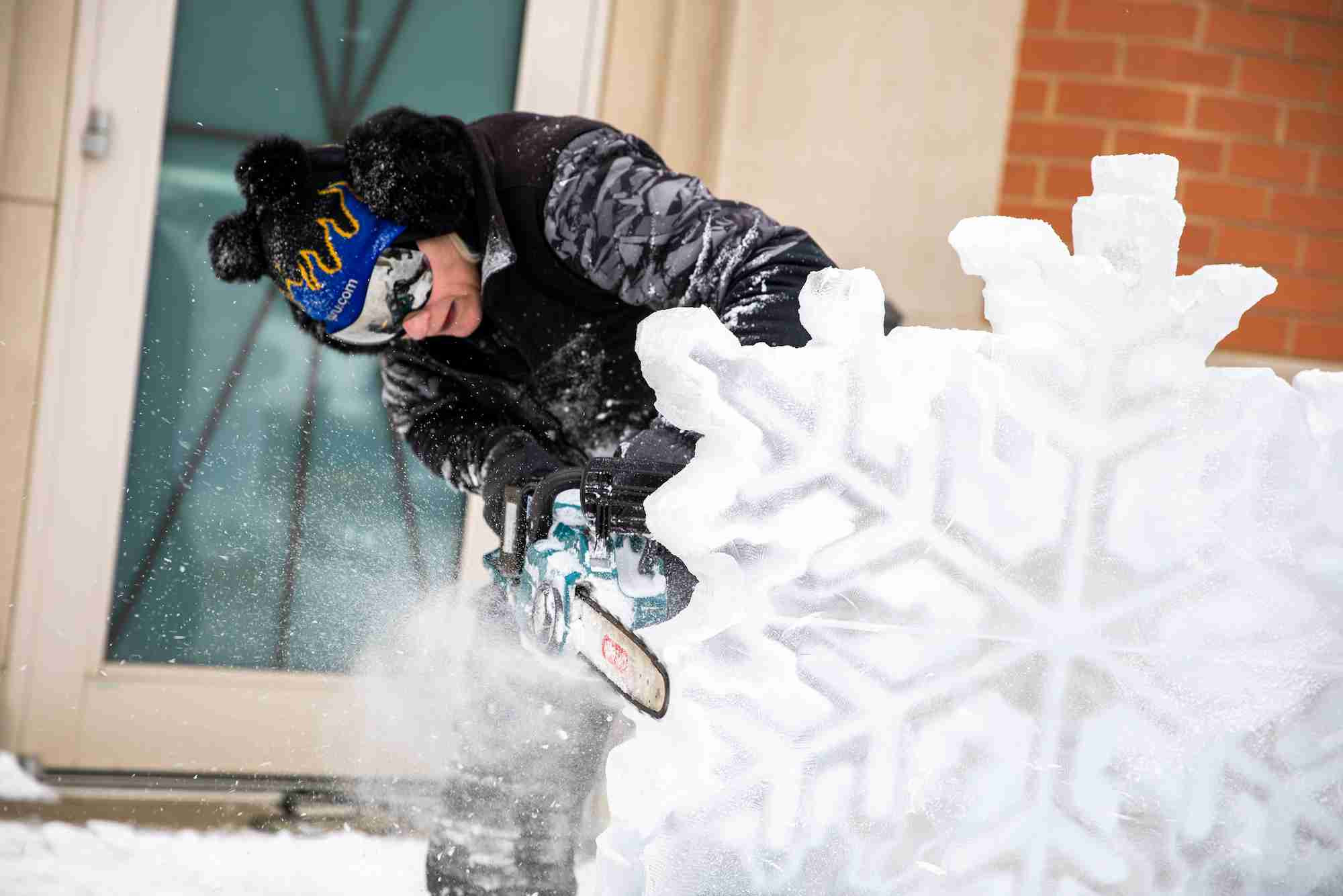 someone carving a snowflake out of ice