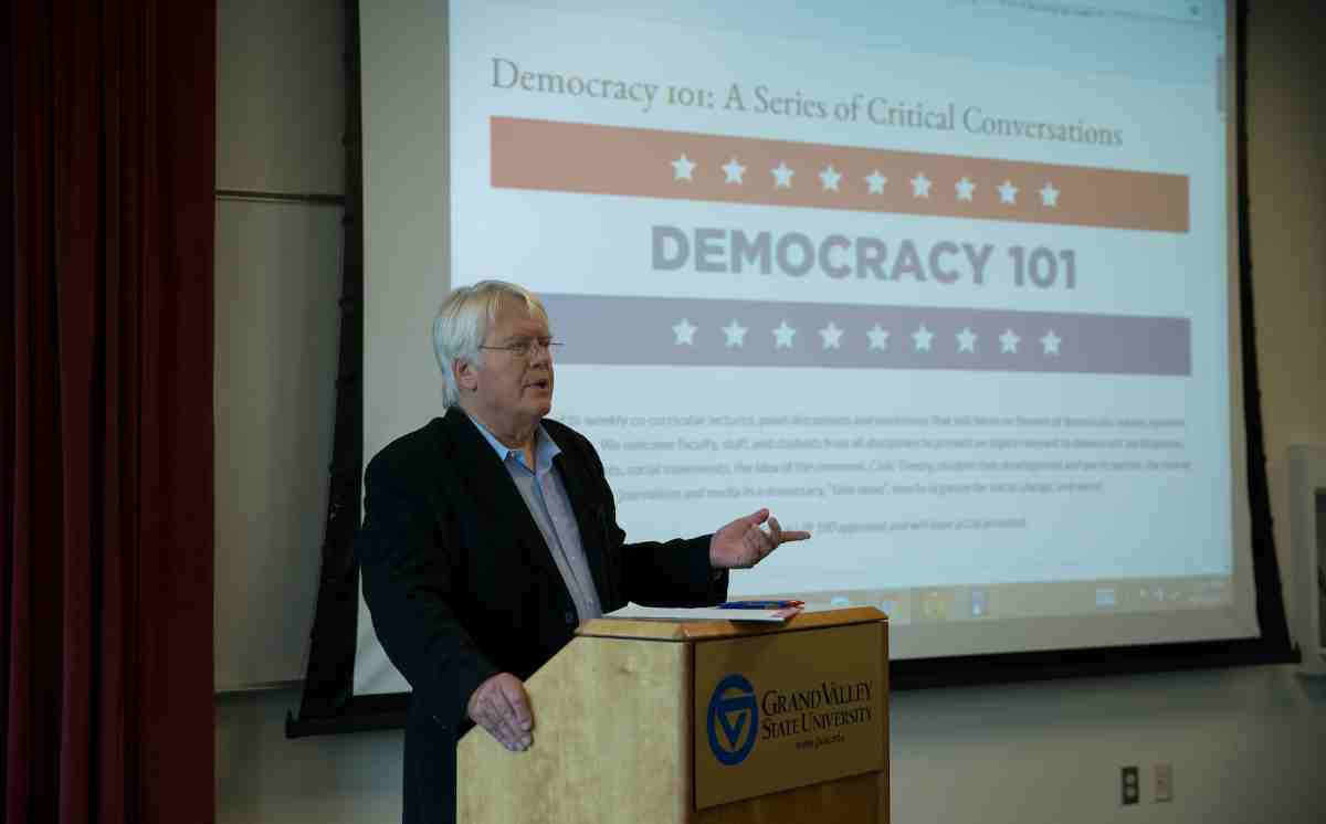 Democracy 101 Seminar with professor talking at a podium in front of the participants