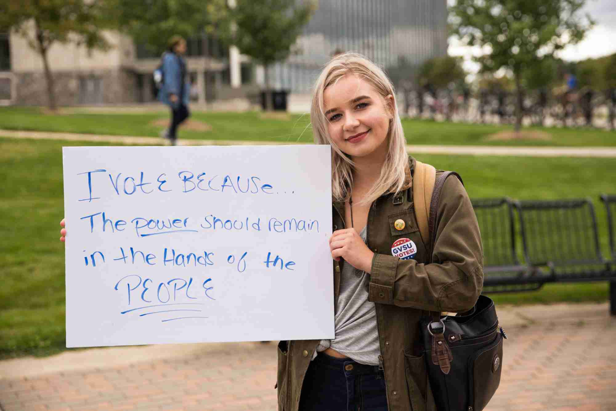 Student holding up I vote because sign