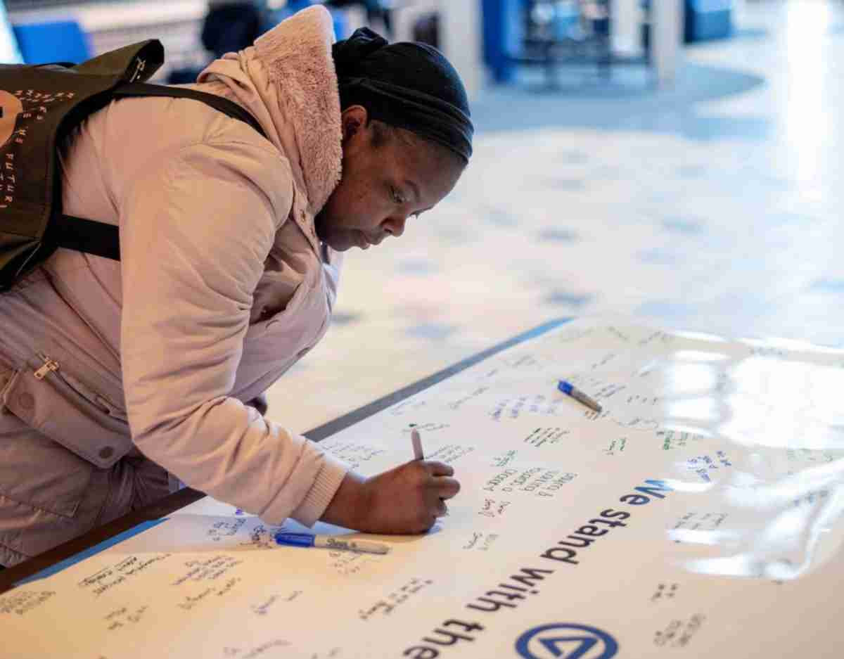 Student signing a banner in support of the MSU community.