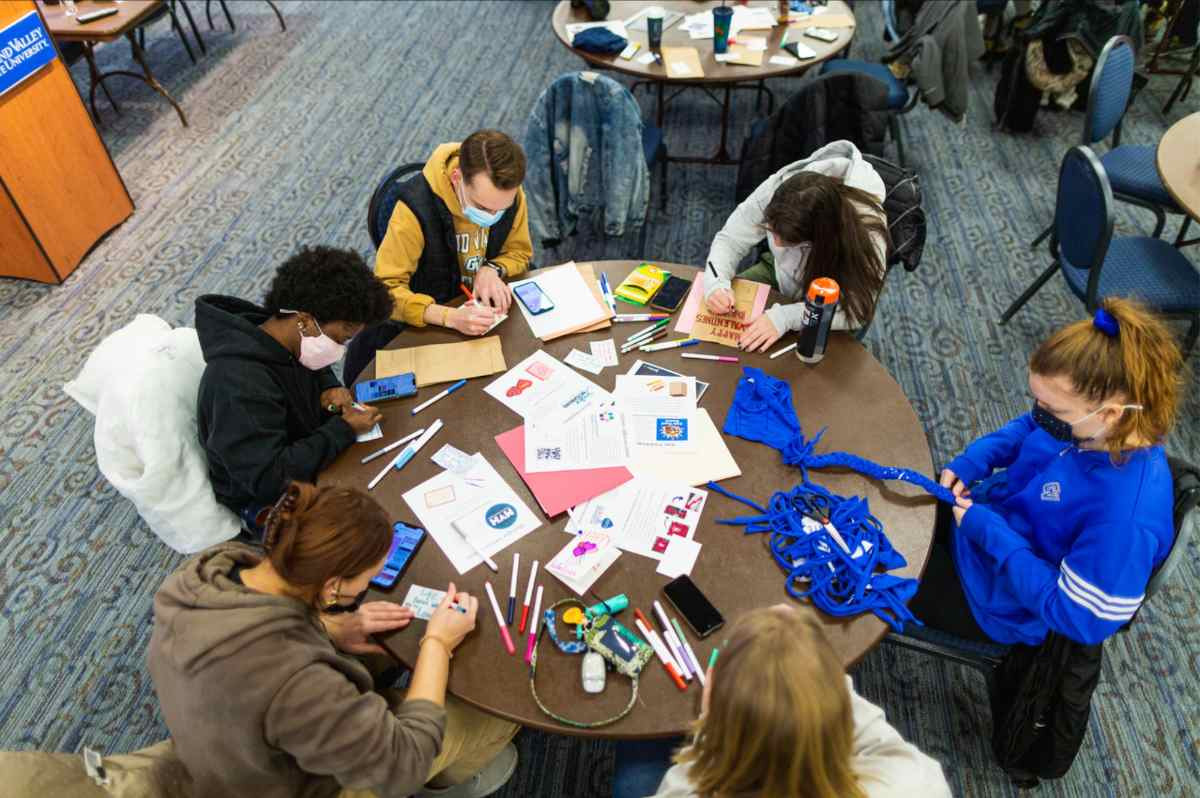Students sitting around a table doing crafts