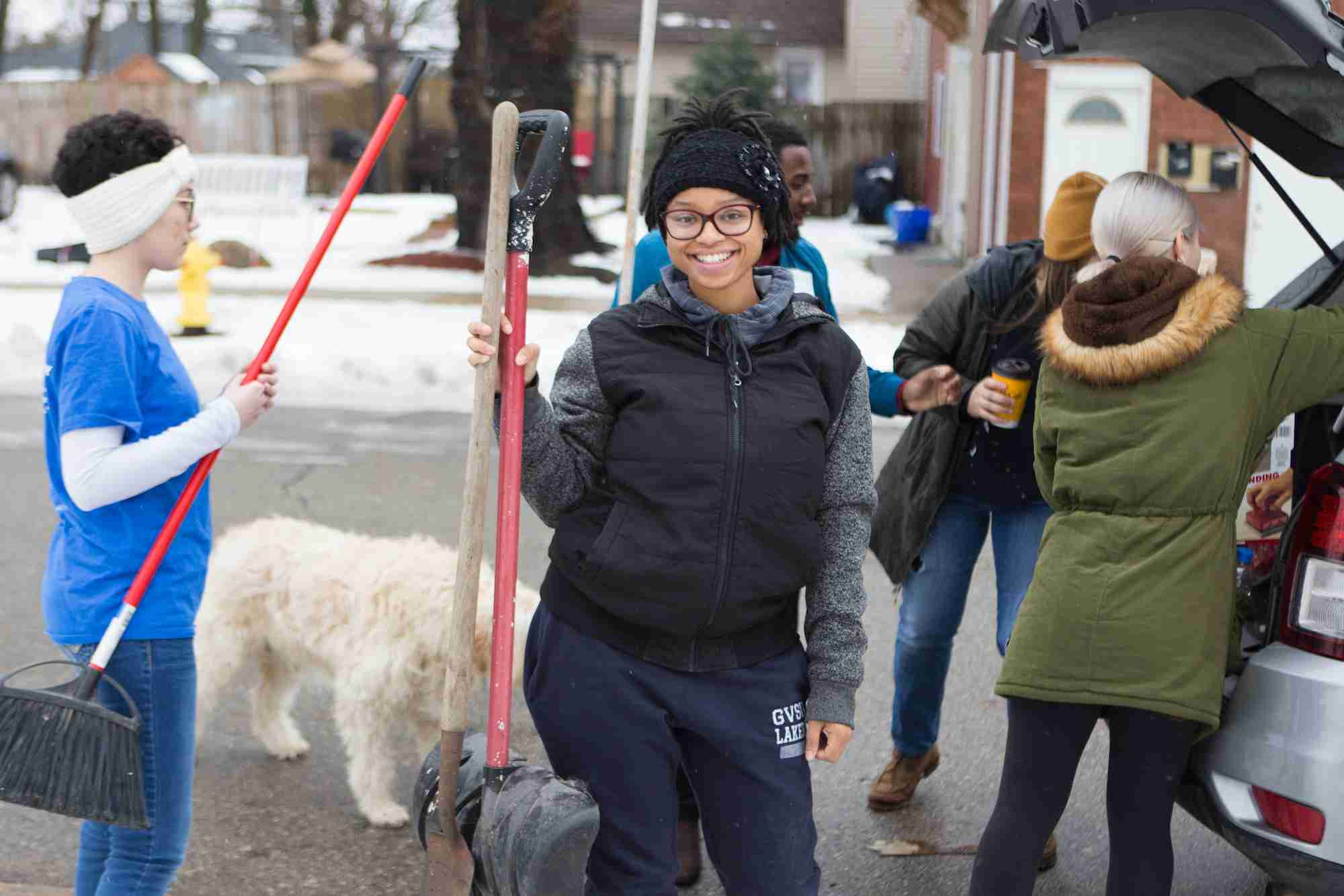 Student holding a shovel smiling for a picture