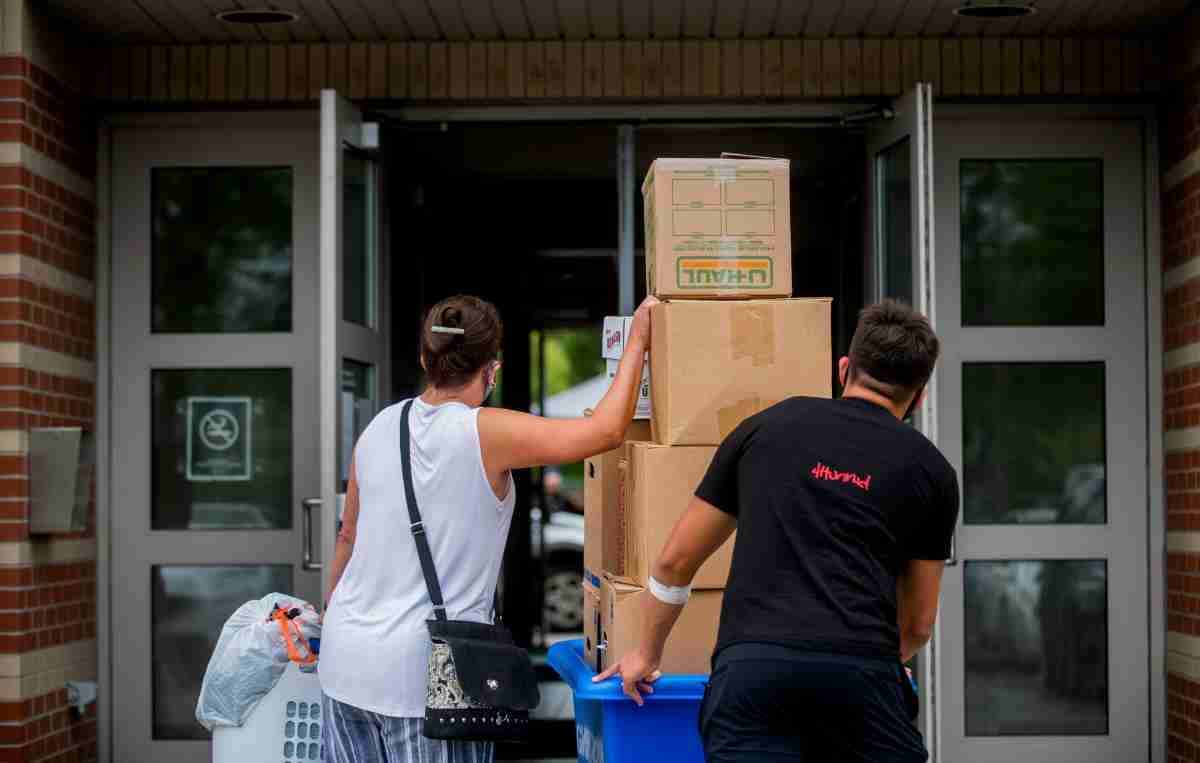 Parent and Student moving boxes into dorm building