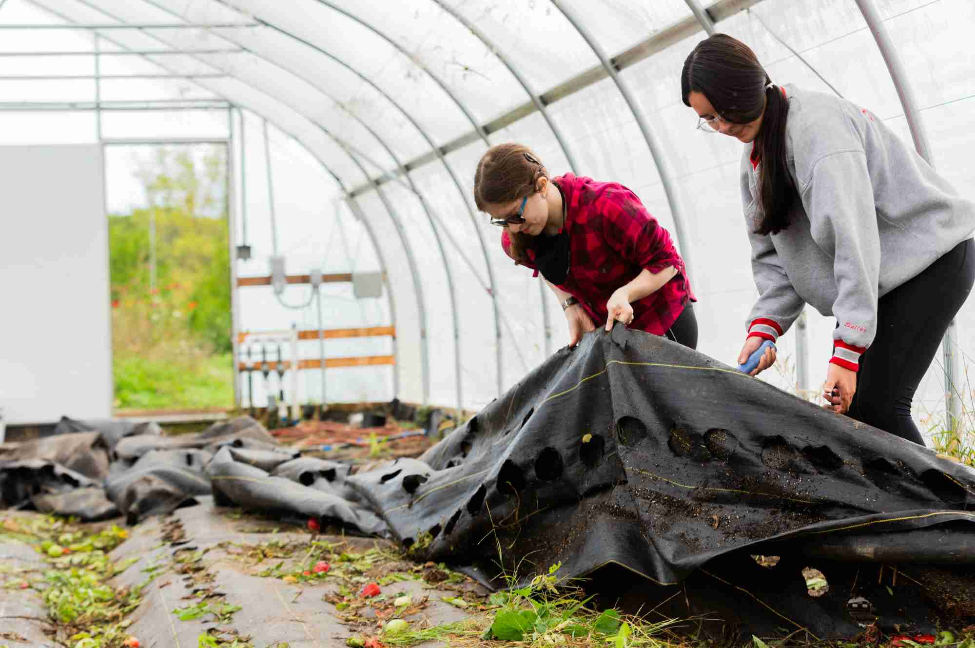 Two students cleaning up greenhouse