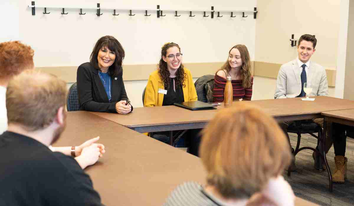 President Mantella sits at a table with members of Student Senate