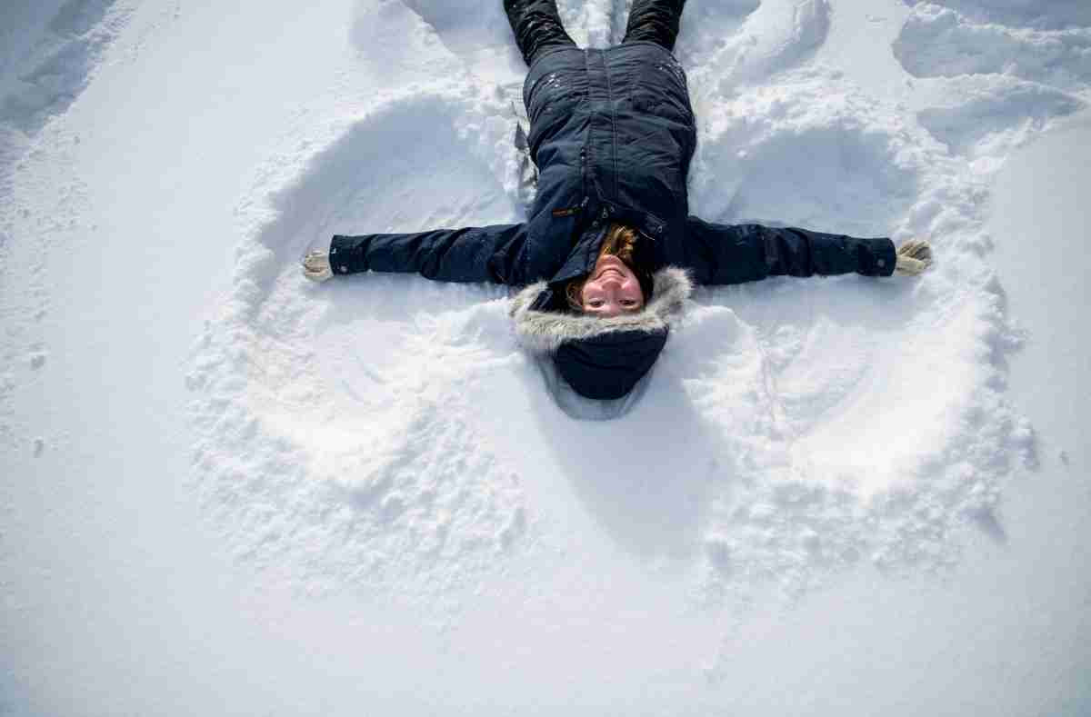 Student making a snow angel in the snow