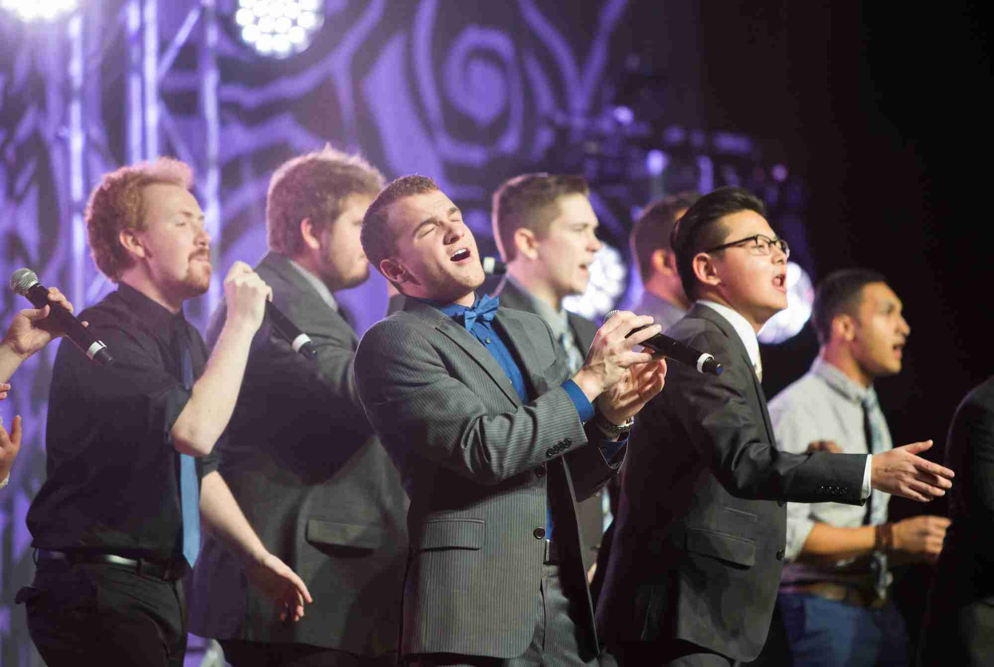 Students singing on stage at the Pres Ball