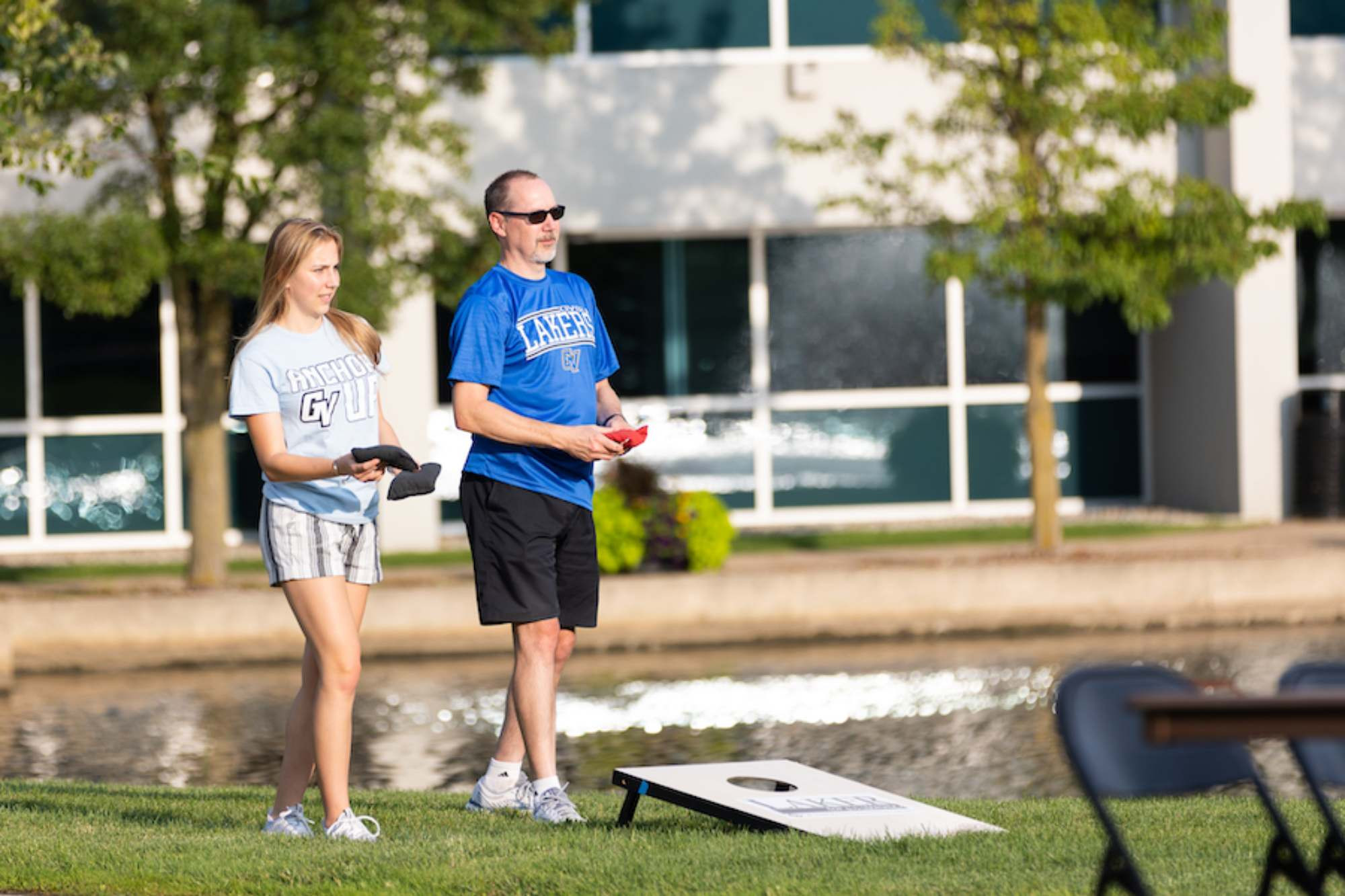 a dad and daughter playing a game of cornhole