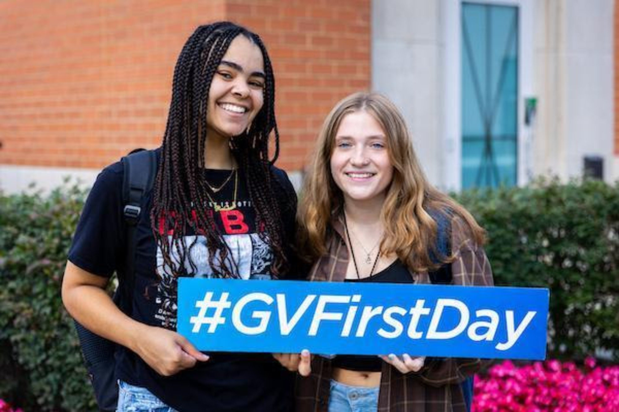 two girls holding a hashtag gv first day sign