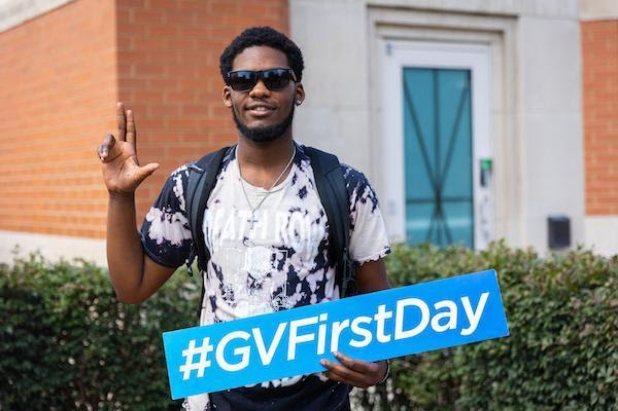 guy doing the anchor up sign and holding a hashtag GV first day sign
