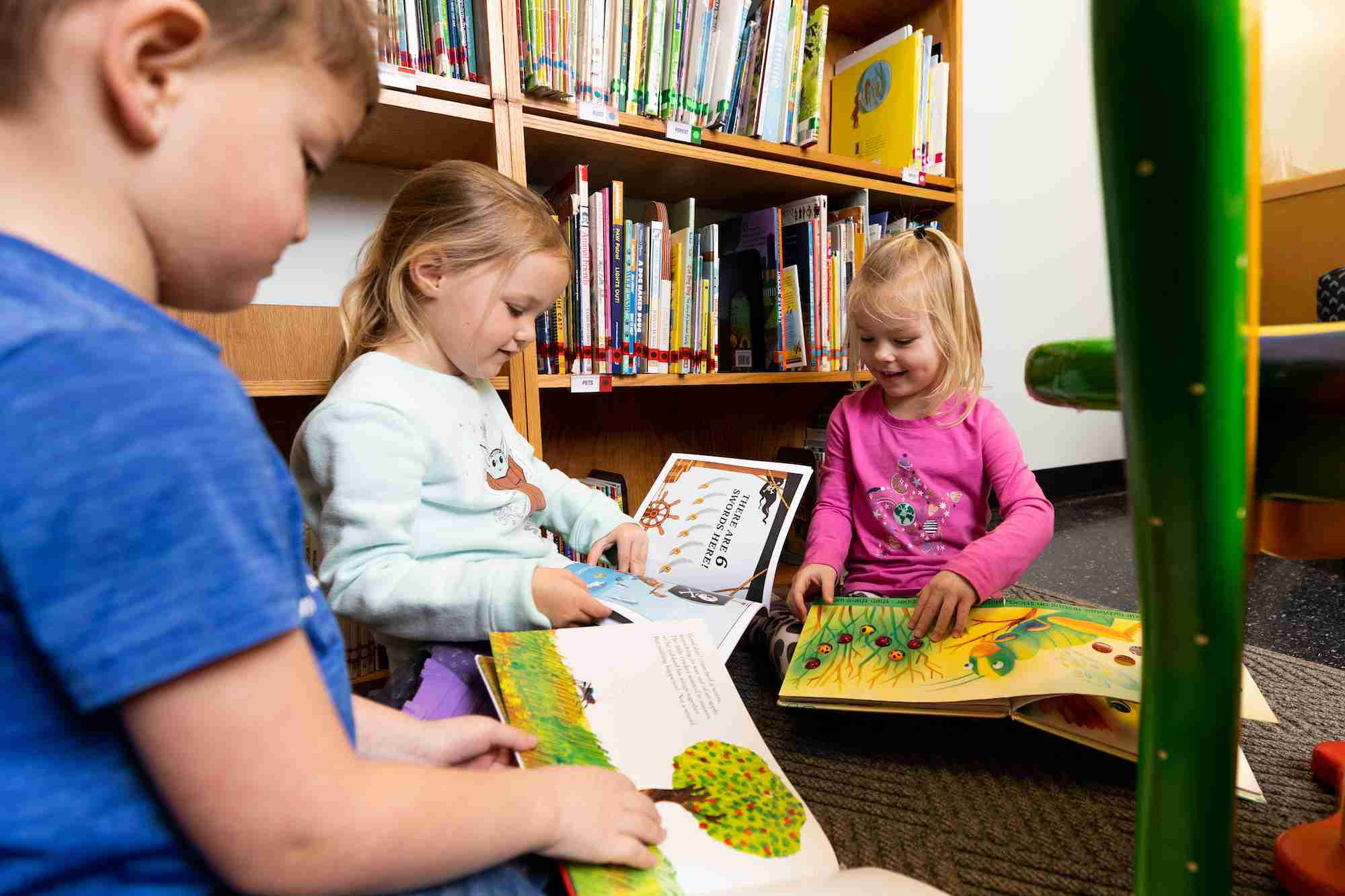 Three kids reading books together