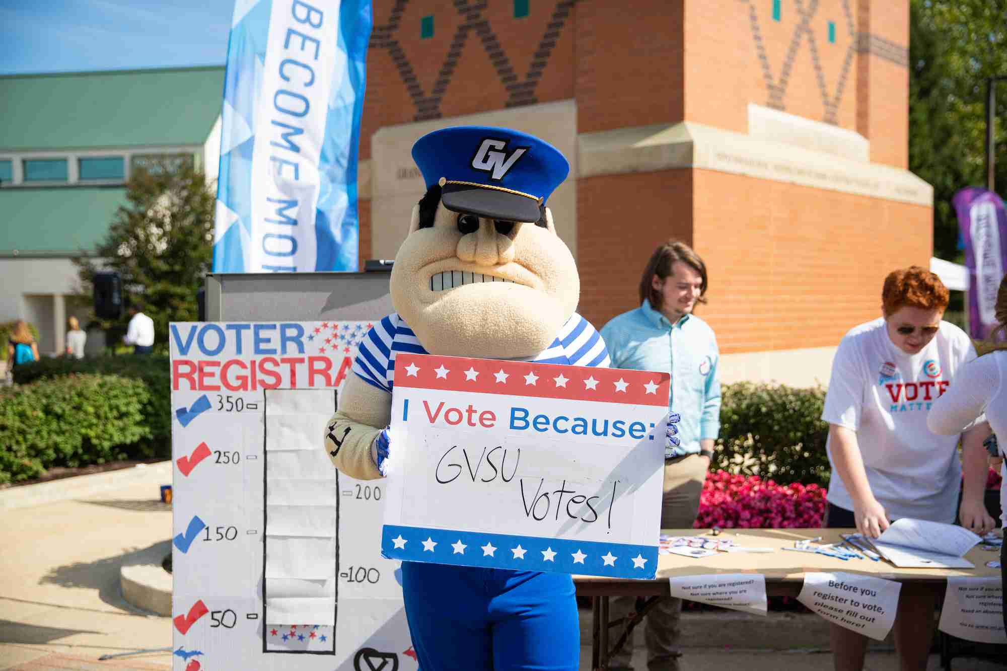 Louie holding a I vote because GVSU Votes sign 