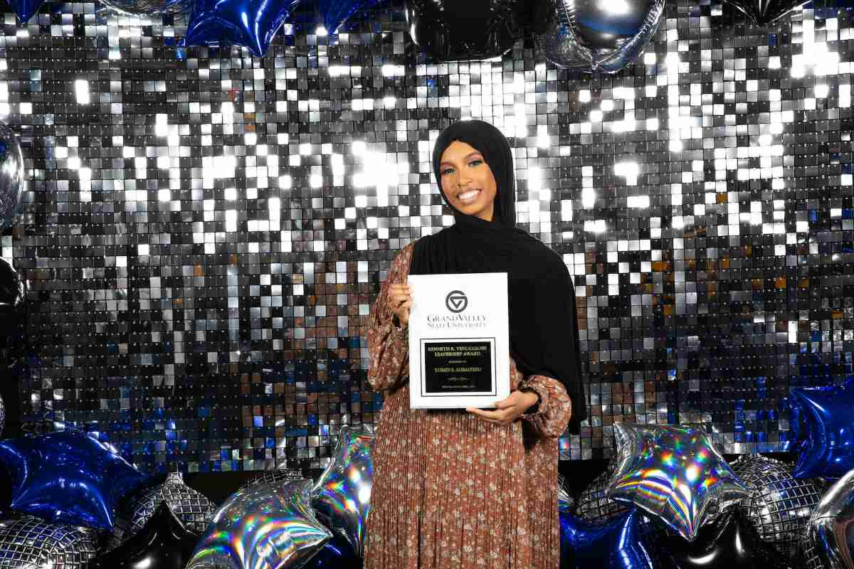 A student taking a picture in the photobooth with their student life award