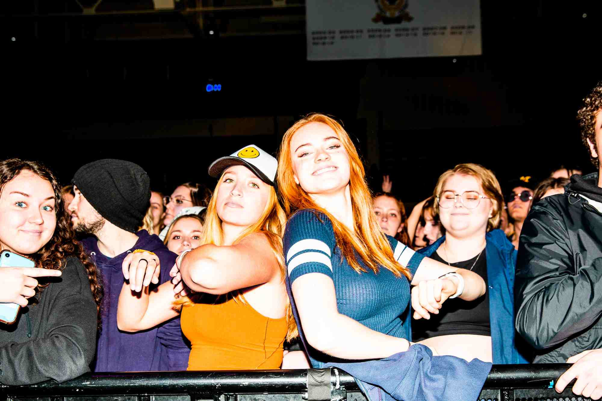 Two students at the spring concert standing back to back looking at the camera