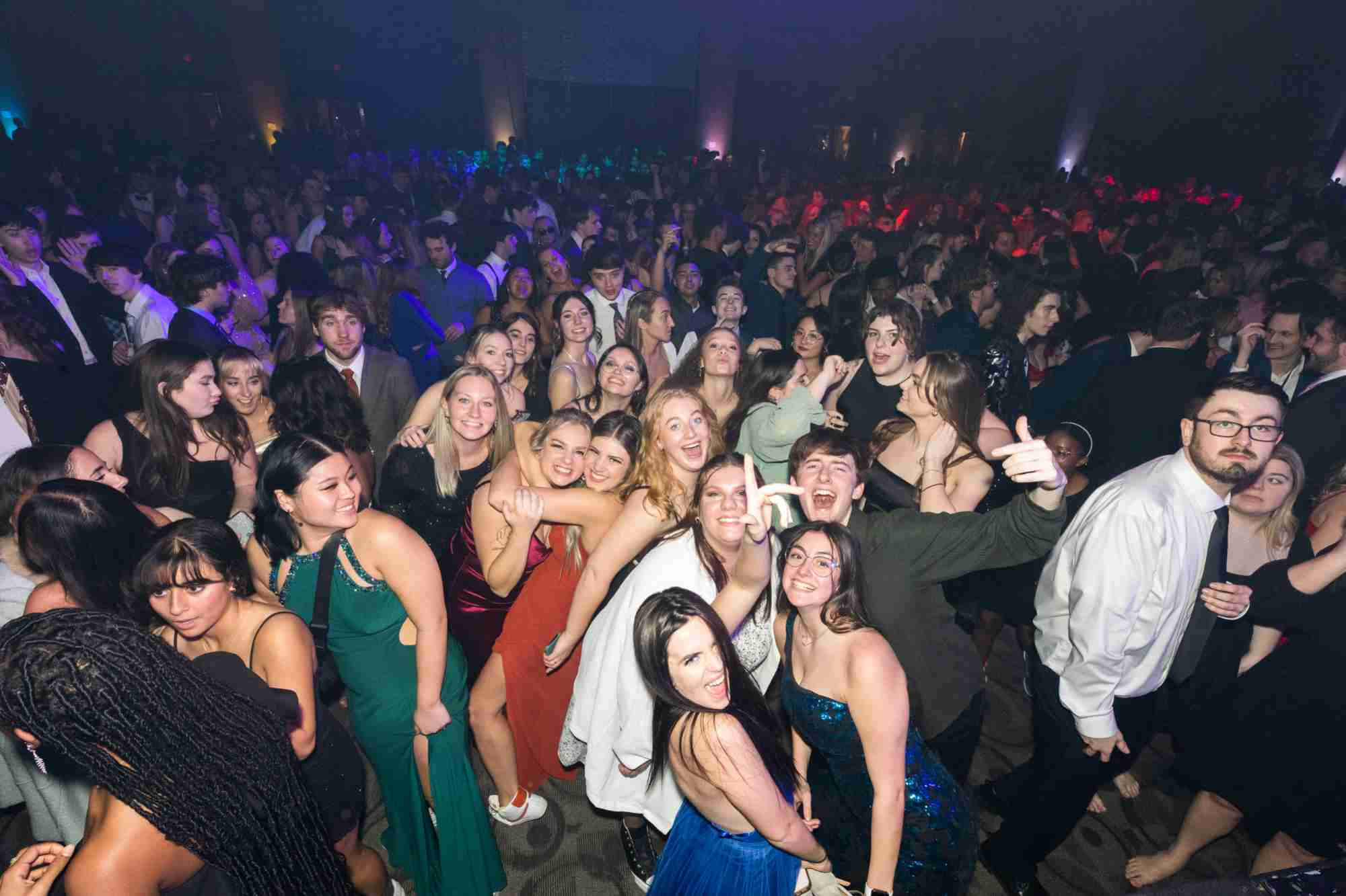 A crowd of formally dressed students smiling and dancing at Presidents' Ball
